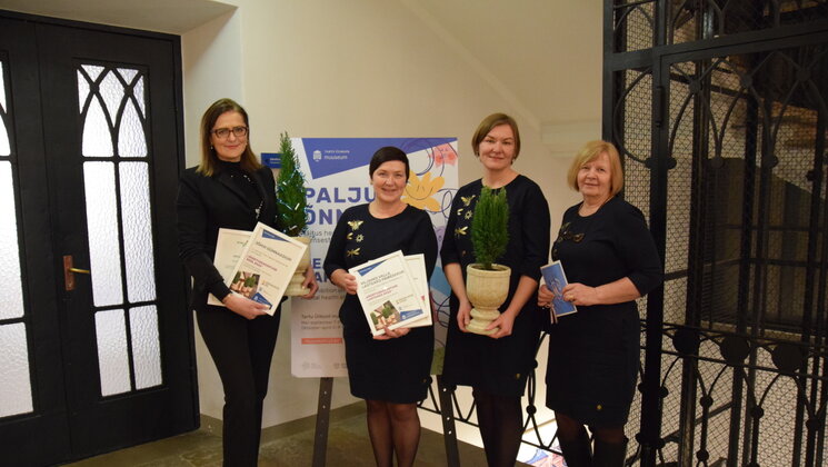 Lasteaiaõpetajad seisavad neljakesti reas ja hoiavad diplomeid käes.