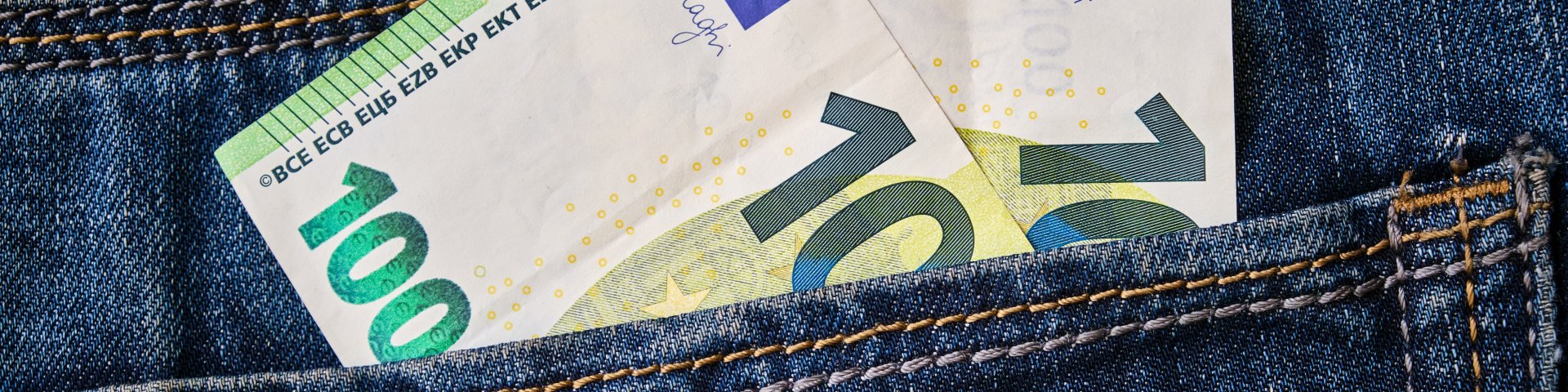 Pükste taskust turritavad välja 100-eurosed rahatähed.
