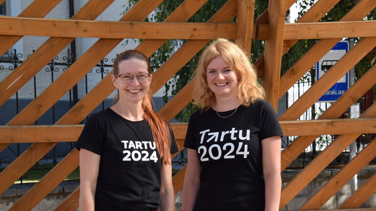 Kaks naist seisavad k&otilde;rvuti. S&auml;rkide peal on kirjas Tartu 2024